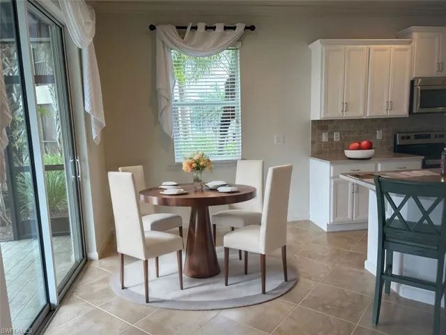 Dining space with crown molding and light tile flooring