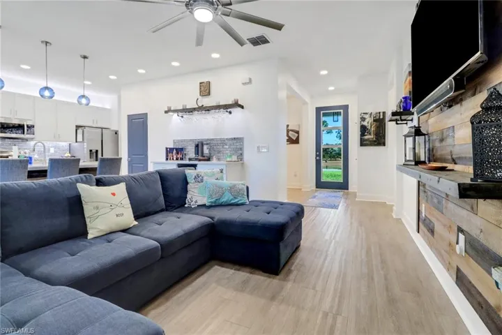 Living room featuring ceiling fan, light wood-type flooring, and sink