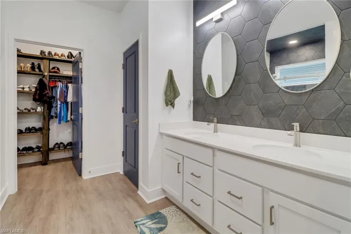 Bathroom with hardwood / wood-style flooring, decorative backsplash, and vanity