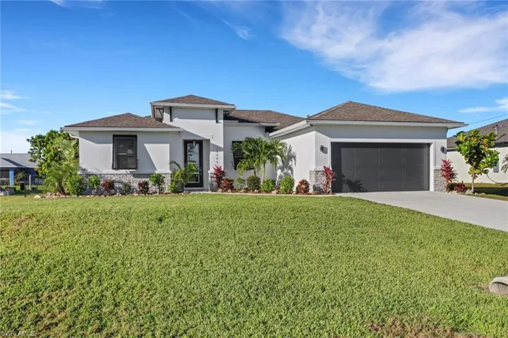 View of front of house featuring a front lawn and a garage