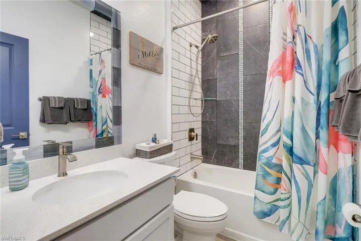 Full bathroom featuring vanity, shower / bath combo, and toilet