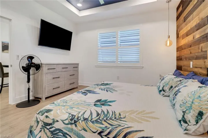 Bedroom with light hardwood / wood-style flooring and wooden walls