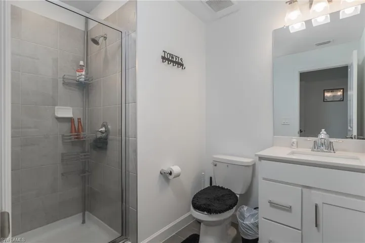Walk-in shower featuring light grey subway tile surround and a clear glass enclosure