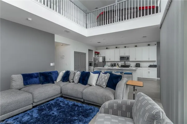 Open-concept interior featuring high ceilings and a second-story balcony with white spindle railings
