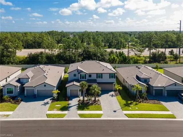 Modern residential property featuring a gray facade, dark trim, and a tiled roof