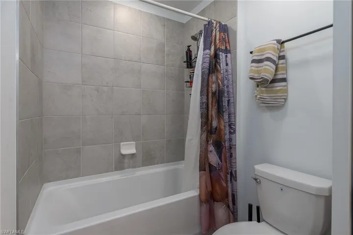 Tub and shower combination featuring light grey subway tile surround