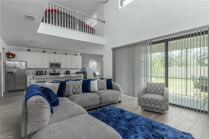 Open-concept living space featuring high ceilings and wood-finish flooring