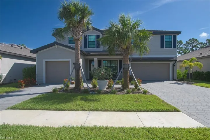 Two-story residence featuring light-colored siding and dark blue window shutters
