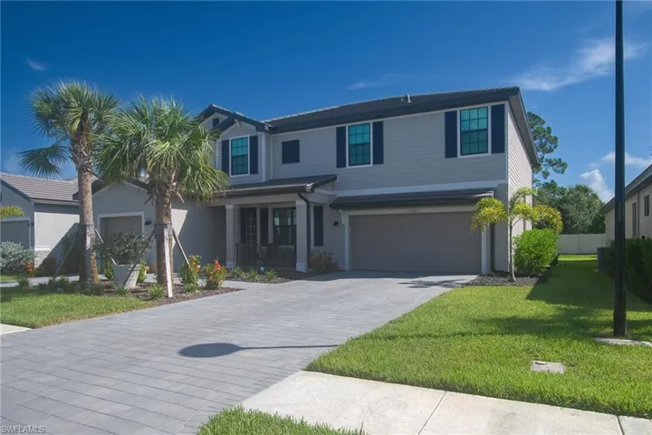 Two-story residence featuring light gray siding with dark trim accents and black window shutters