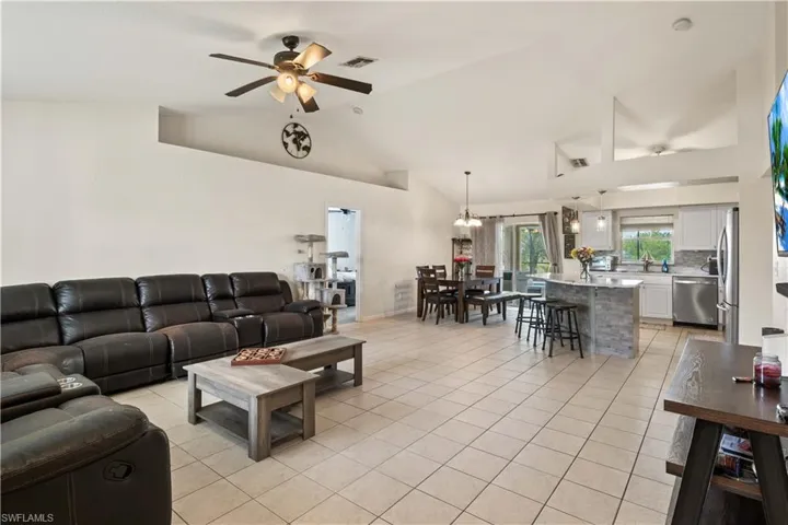 Spacious, open concept living, dinning and kitchen area, with high ceilings and plenty of natural light, creating a welcoming and airy atmosphere.