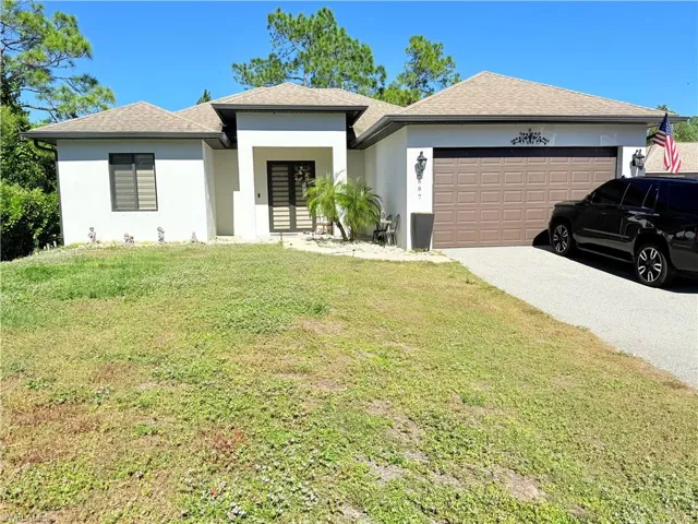 View of front facade featuring a front yard and a garage