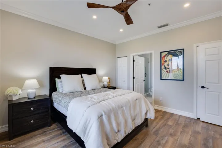 Bedroom with crown molding, dark wood-style flooring, recessed lighting, ceiling fan, and a closet