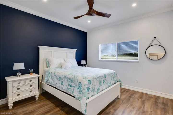 Bedroom with crown molding, dark wood-type flooring, a ceiling fan, and recessed lighting