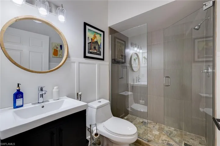 Full bathroom with vanity and a shower stall