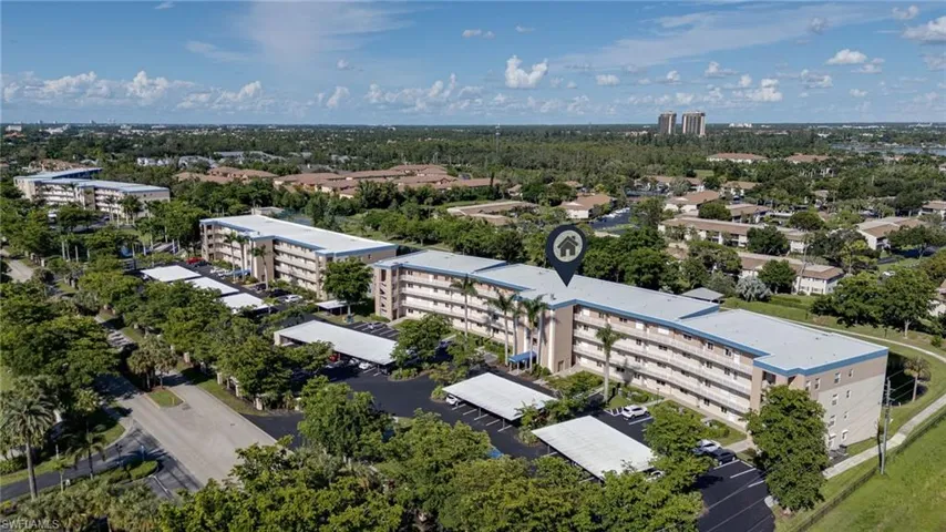 Aerial view of apartment complex / building and a tree filled landscape