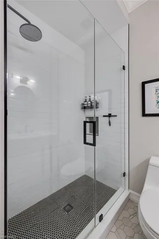 Bathroom with a stall shower and tile patterned floors