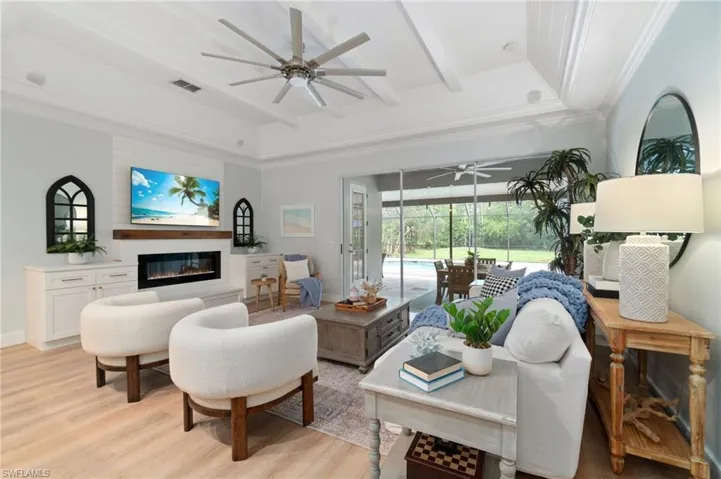 Custom wood detailed ceiling adds charm and character to this cozy living space, along with the electric, built-in fireplace framed by custom storage cabinets