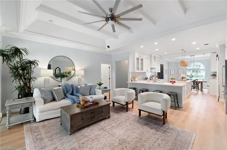 Open living and kitchen/dining space brings everyone together, and the details of the wood ceiling, and crown molding make this space even more warm and inviting