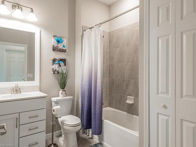 Beautifully tiled spare bathroom with granite countertop for family and guests set on opposite side of primary bedroom perfect for privacy complete with linen closet