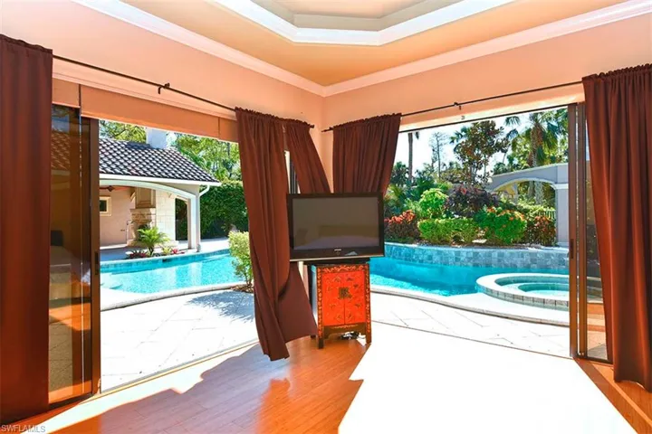 Master bedroom with surround sliders to pool