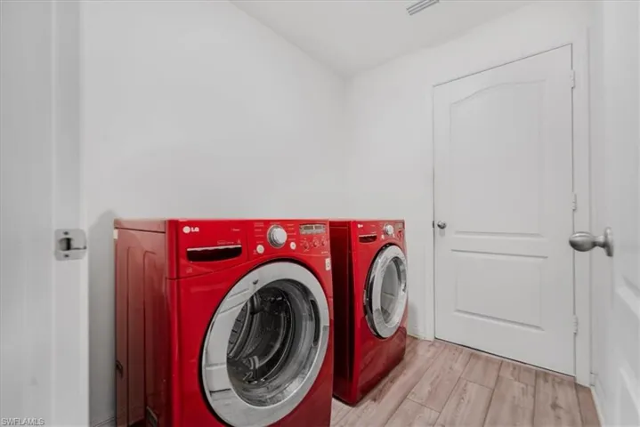 Laundry room featuring independent washer and dryer and wood finished floors