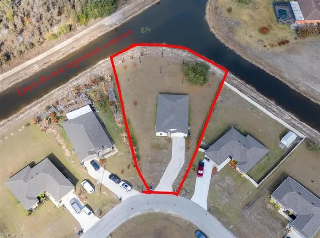 Aerial perspective of suburban area with a nearby body of water and property boundaries highlighted
