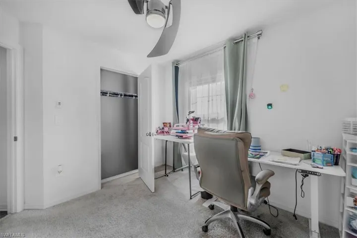 Home office featuring light carpet and baseboards