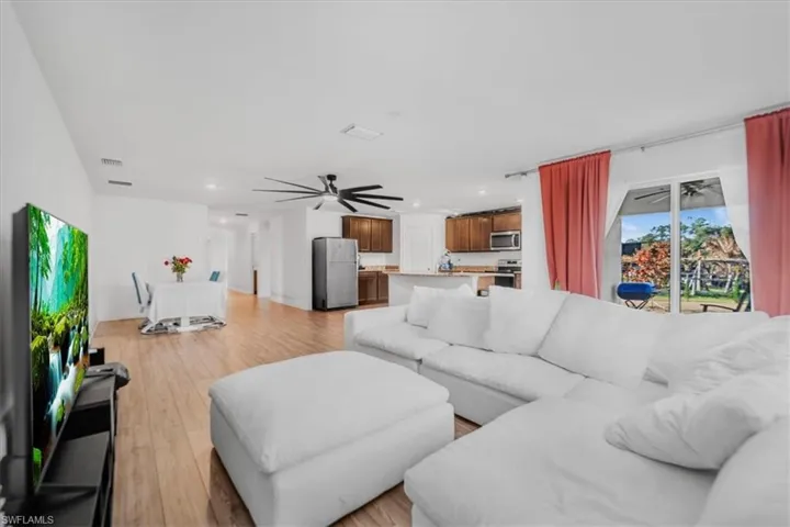 Living area with ceiling fan, light wood-style floors, and recessed lighting