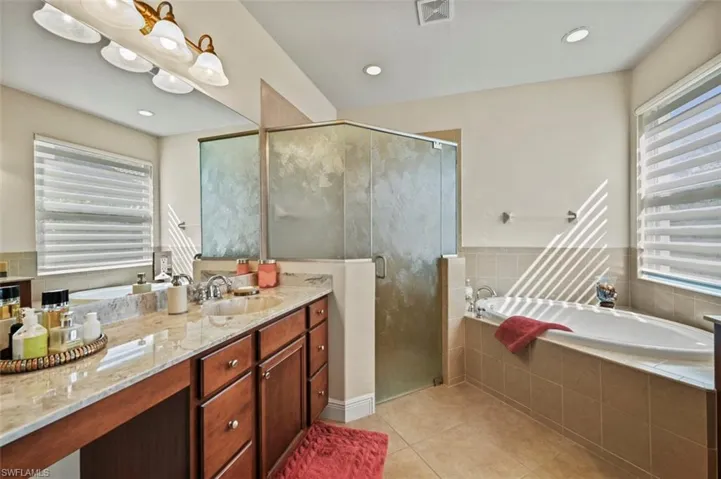 Bathroom with light tile patterned flooring, a bath, a shower stall, vanity, and recessed lighting