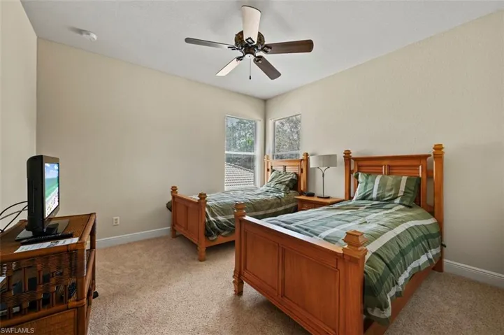 Bedroom with light colored carpet and ceiling fan