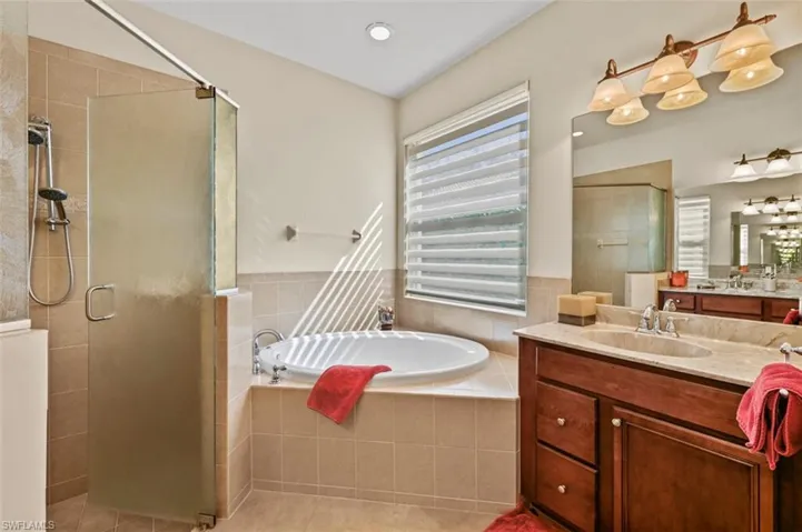 Bathroom with vanity, a stall shower, a bath, light tile patterned floors, and recessed lighting
