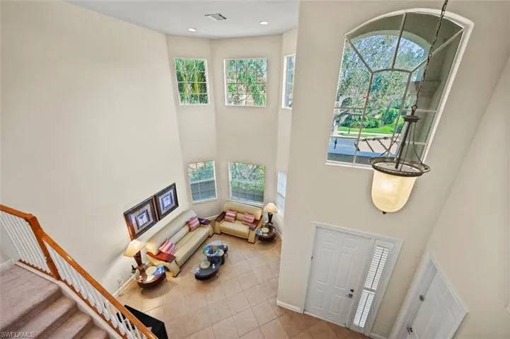 Tiled foyer with a high ceiling, recessed lighting, and stairway