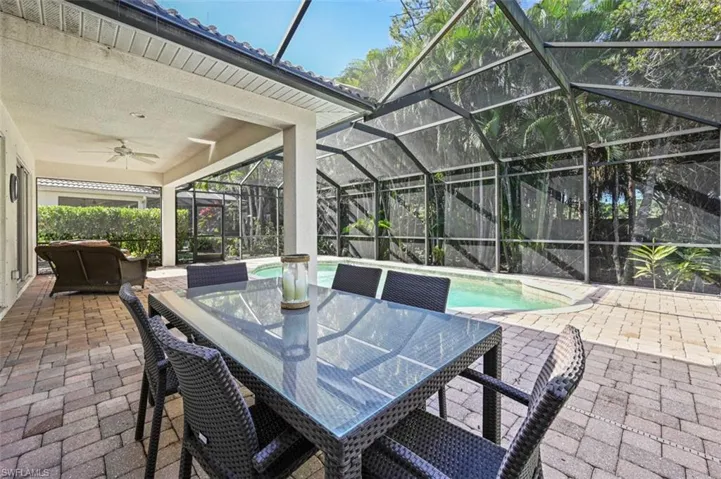 View of patio / terrace featuring a lanai, ceiling fan, an outdoor pool, and outdoor dining area