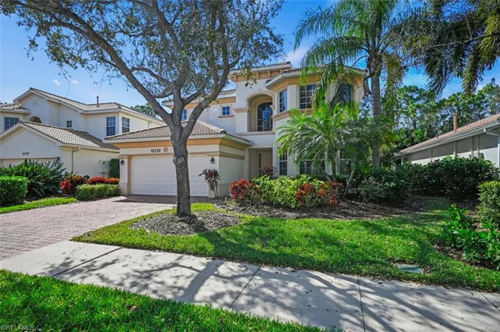 Mediterranean / spanish-style home featuring stucco siding, decorative driveway, a tile roof, and a front lawn
