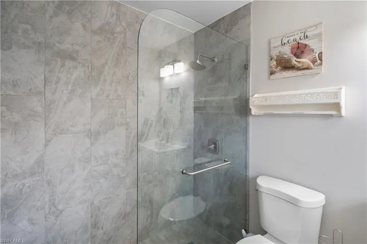Full bathroom with toilet and a stall shower