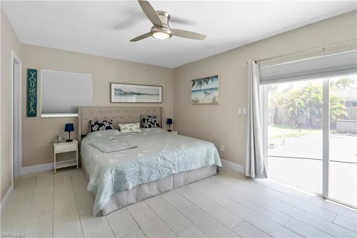 Bedroom featuring access to exterior, wood finish floors, and ceiling fan