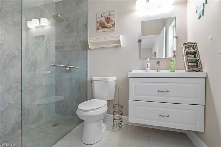 Full bathroom with vanity, a walk in shower, and light tile patterned floors