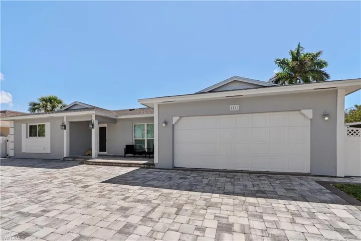 Single story home with stucco siding, decorative driveway, and an attached garage