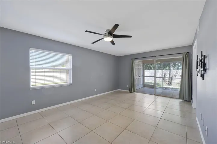 Spare room featuring light tile patterned flooring, baseboards, and a ceiling fan