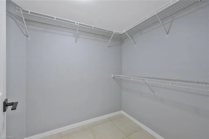 Walk in closet with light tile patterned floors
