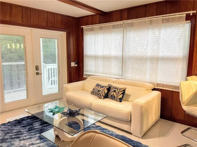 Living room with wood walls and beam ceiling