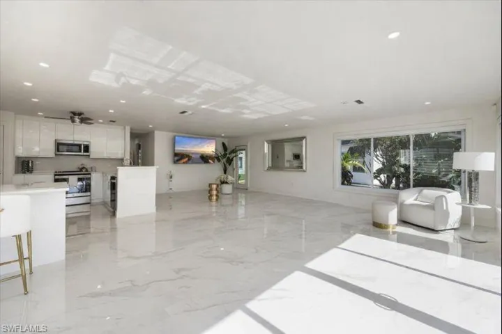 Living room with light marble finish floors and recessed lighting
