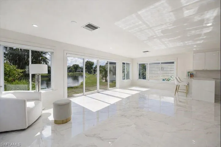 Unfurnished living room with light marble finish flooring, recessed lighting, a water view, and plenty of natural light