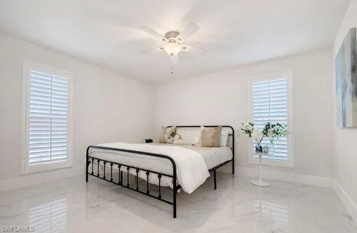 Bedroom with marble tiled floors and ceiling fan