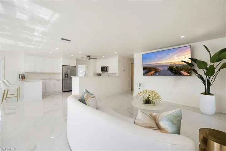 Living room with recessed lighting and light marble finish flooring