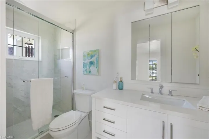 Full bath with plenty of natural light, vanity, and a marble finish shower
