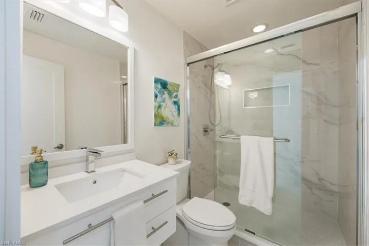 Bathroom with vanity and a marble finish shower