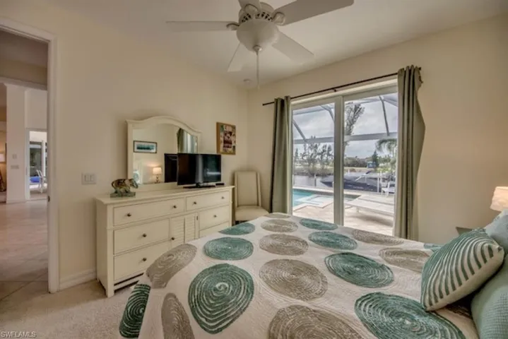 Bedroom with ceiling fan, access to exterior, and light tile flooring