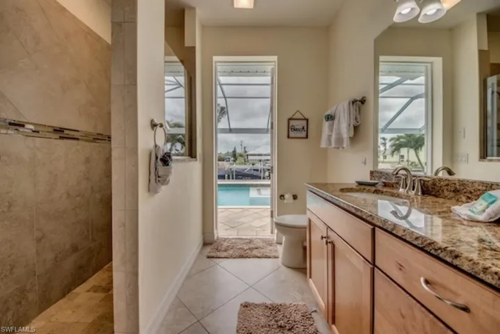 Bathroom with tile flooring, toilet, and vanity with extensive cabinet space
