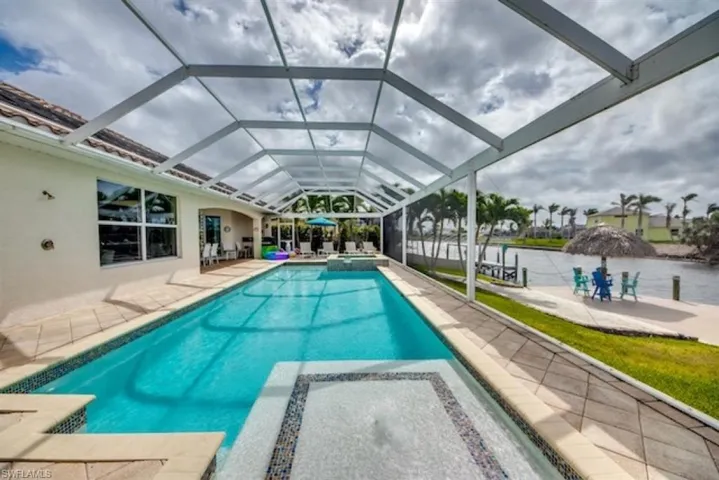 View of swimming pool featuring glass enclosure and a patio area